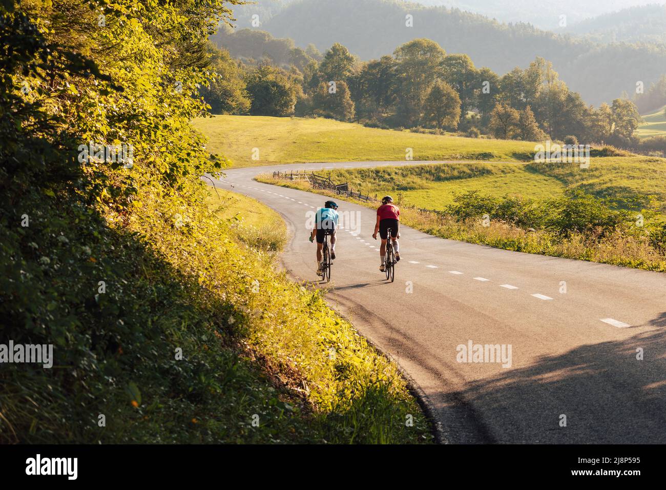 Two road cyclists, male and female during training at beautiful nature