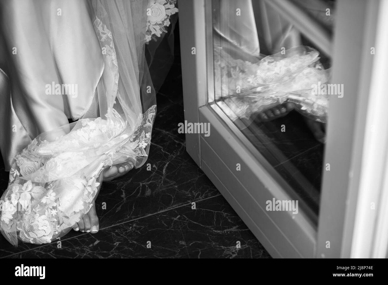 Legs of the bride with a veil near the mirror. Stock Photo