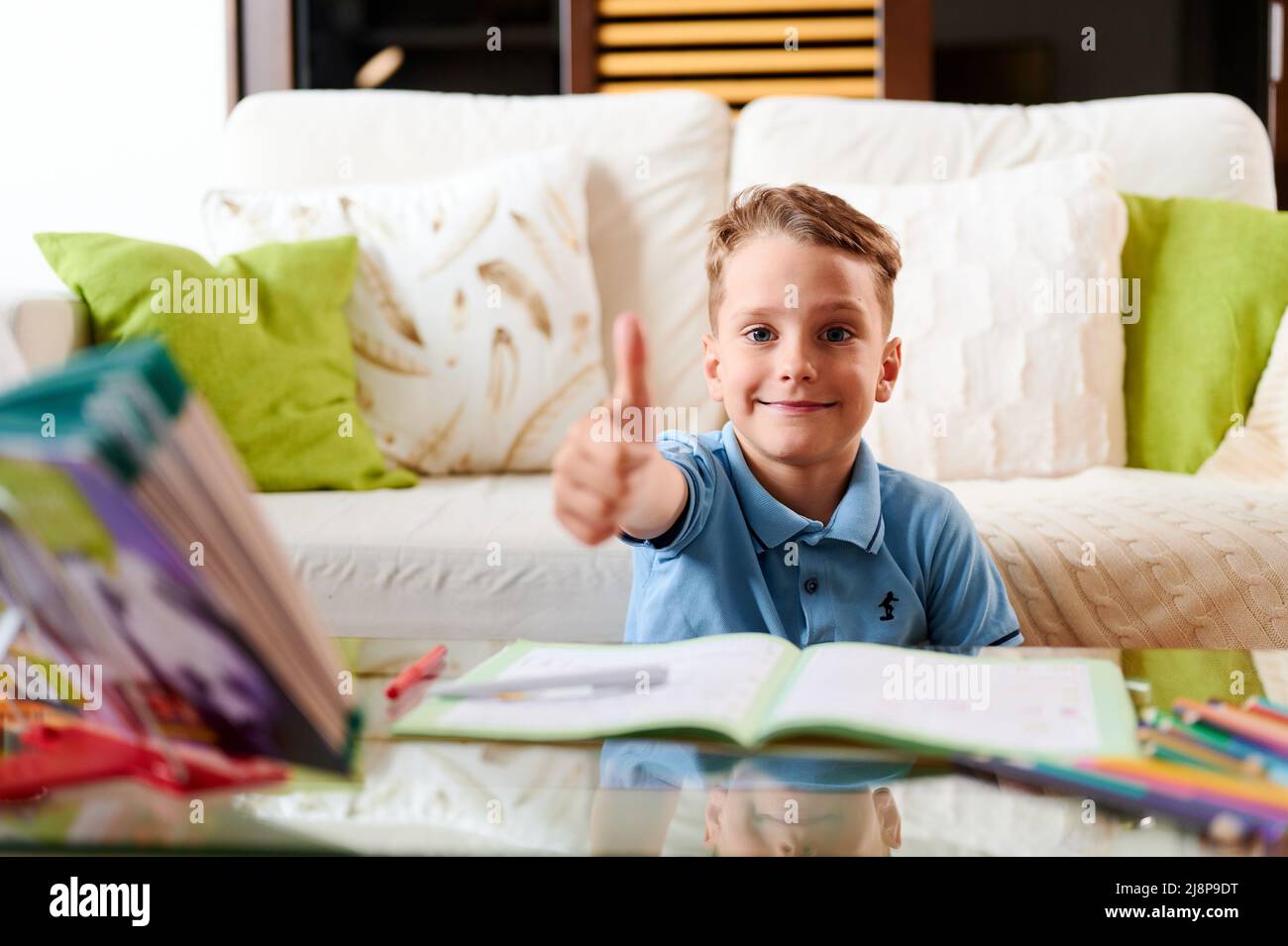 Caucasian school boy doing homework and shows thumb up gesture Stock ...