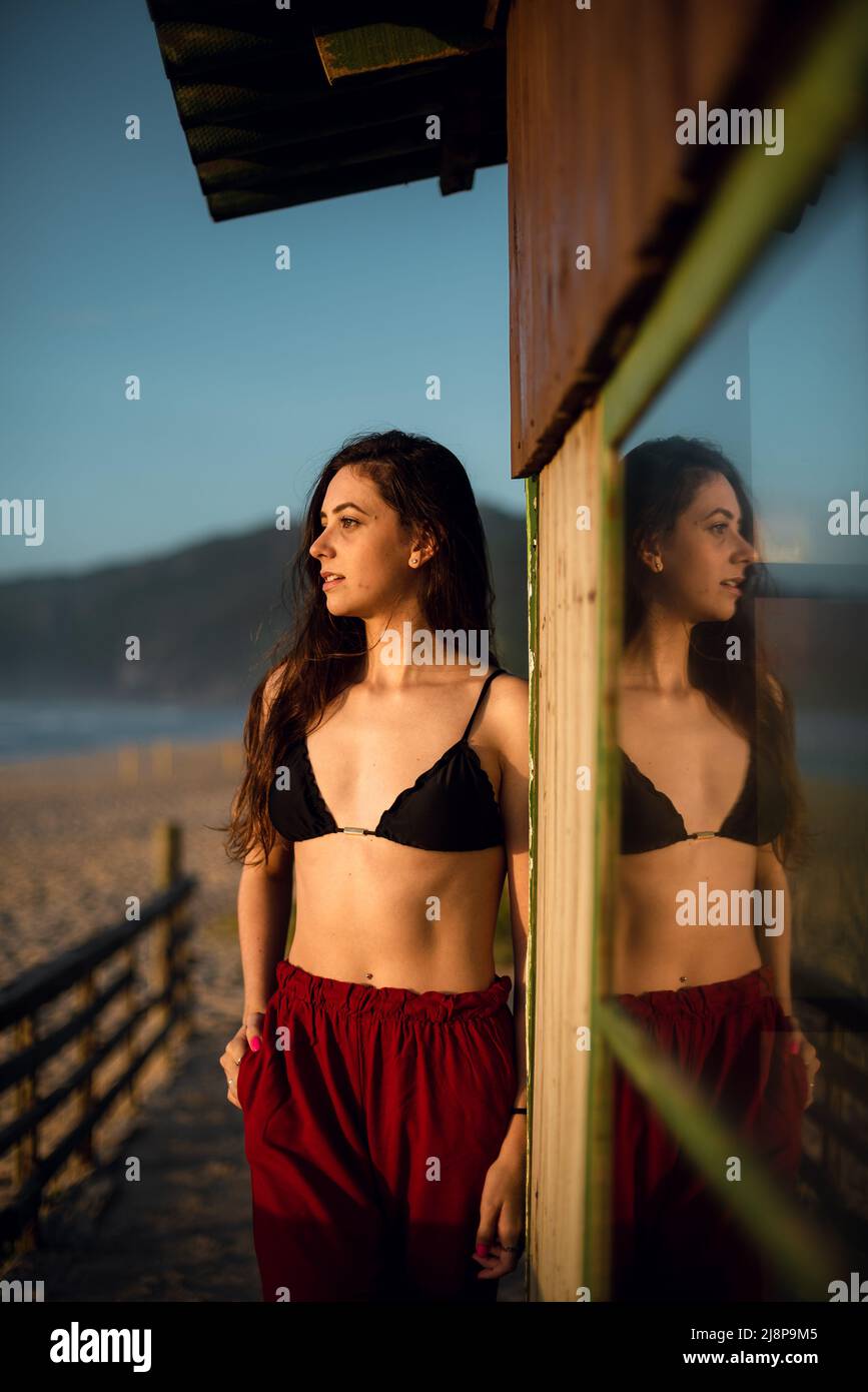 Young woman with bikini looking at horizon at the beach Stock Photo