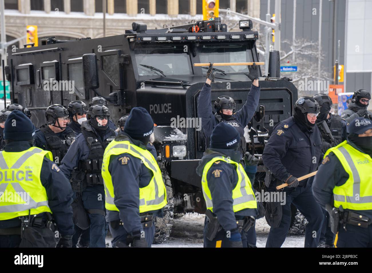 A police officer holds up a baton outside Chateau Laurier on the second day of clearing out the Freedom Convoy protest in Ottawa, Canada. Stock Photo