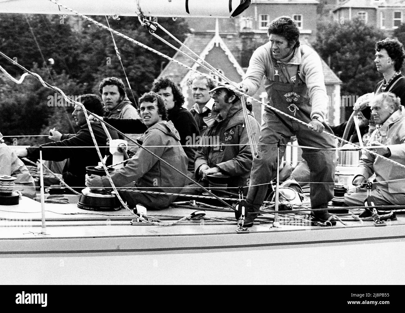 AJAXNETPHOTO. AUGUST, 1981. - COWES WEEK RACING - MORNING CLOUD IV OWNER EDWARD HEATH SAILING ADVISER OWEN PARKER SEEN ON DECK THIRD FROM RIGHT PULLING HALYARD. DESIGNER RON HOLLAND IS HELMING YACHT. PHOTO:JONATHAN EASTLAND/AJAX REF:780708 1  67 Stock Photo