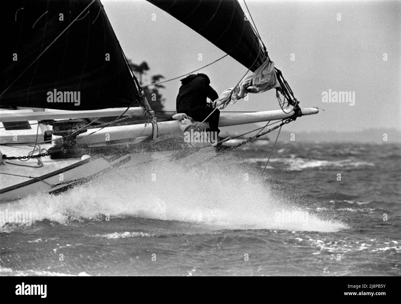 AJAXNETPHOTO. 16TH SEPTEMBER, 1977. SOLENT, ENGLAND. - OLD GAFFERS RACE - SKIPPER OF THE YACHT VENUS, PAUL ERLING JOHNSON, ON THE BOWSPRIT OF HIS YACHT STOWING SAIL IN HEAVY WEATHER. YACHT WAS LATER LOST OFF NORTH COAST OF AUSTRALIA.PHOTO:JONATHAN EASTLAND/AJAX REF:771609 1 Stock Photo