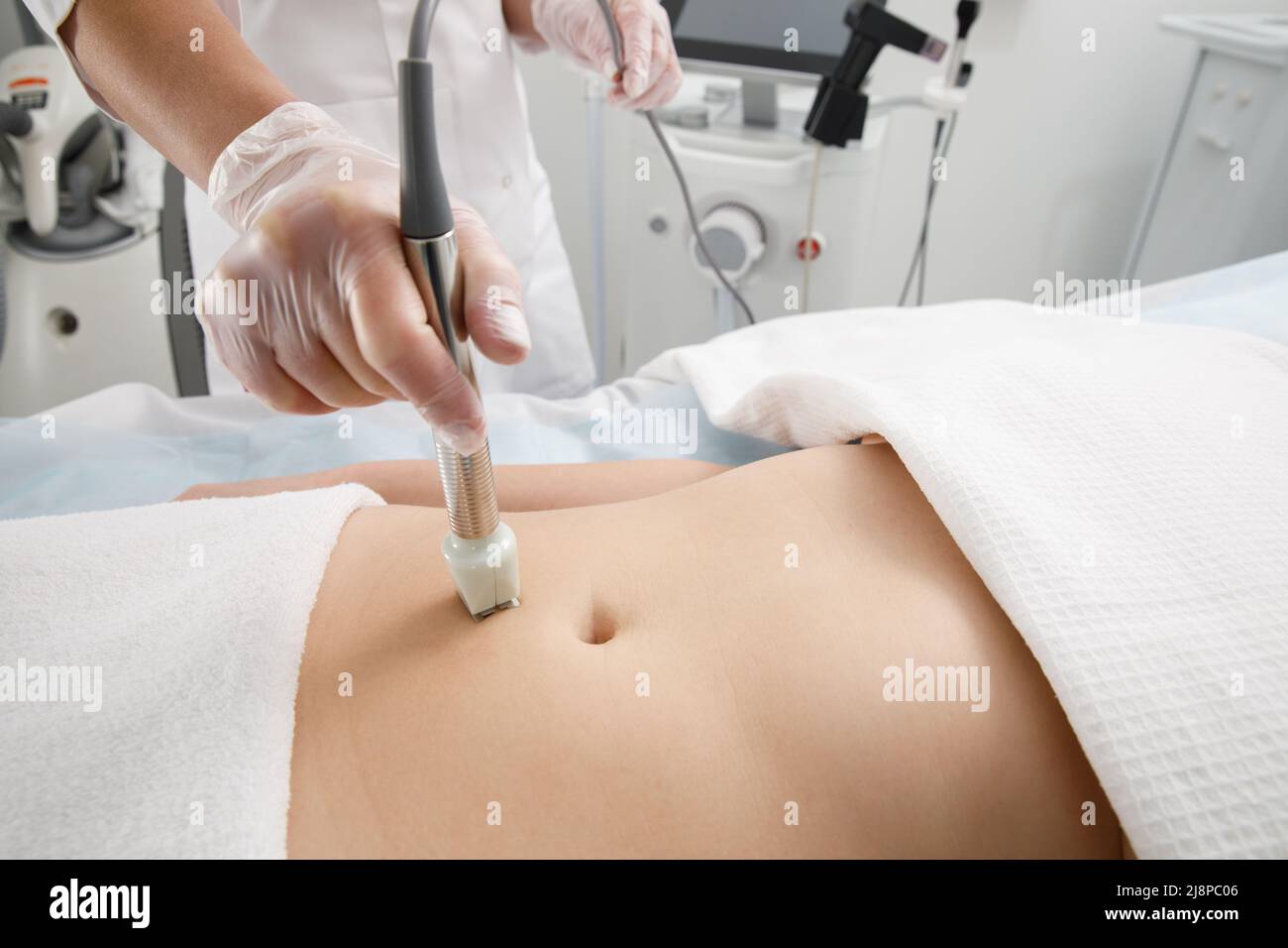 A woman undergoes an anti-cellulite procedure in a cosmetology clinic. Stock Photo