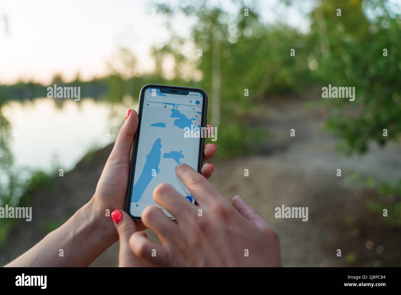 A couple of tourists on a camping trip, looking for the way by GPS on a smartphone. An application with a map of the area for a smartphone. Stock Photo