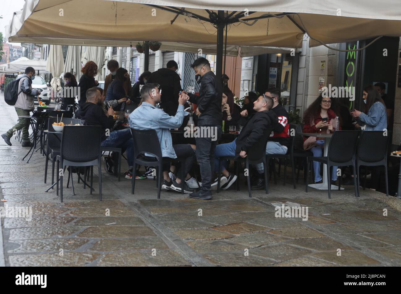 People have a drink on a bar terrace at the Navigli in downtown Milan on April 26, 2021 as bars, restaurants, cinemas and concert halls partially reopen across Italy in a boost for coronavirus-hit businesses Featuring: Atmosphere Where: Milan, Italy When: 26 Apr 2021 Credit: Mairo Cinquetti/WENN Stock Photo