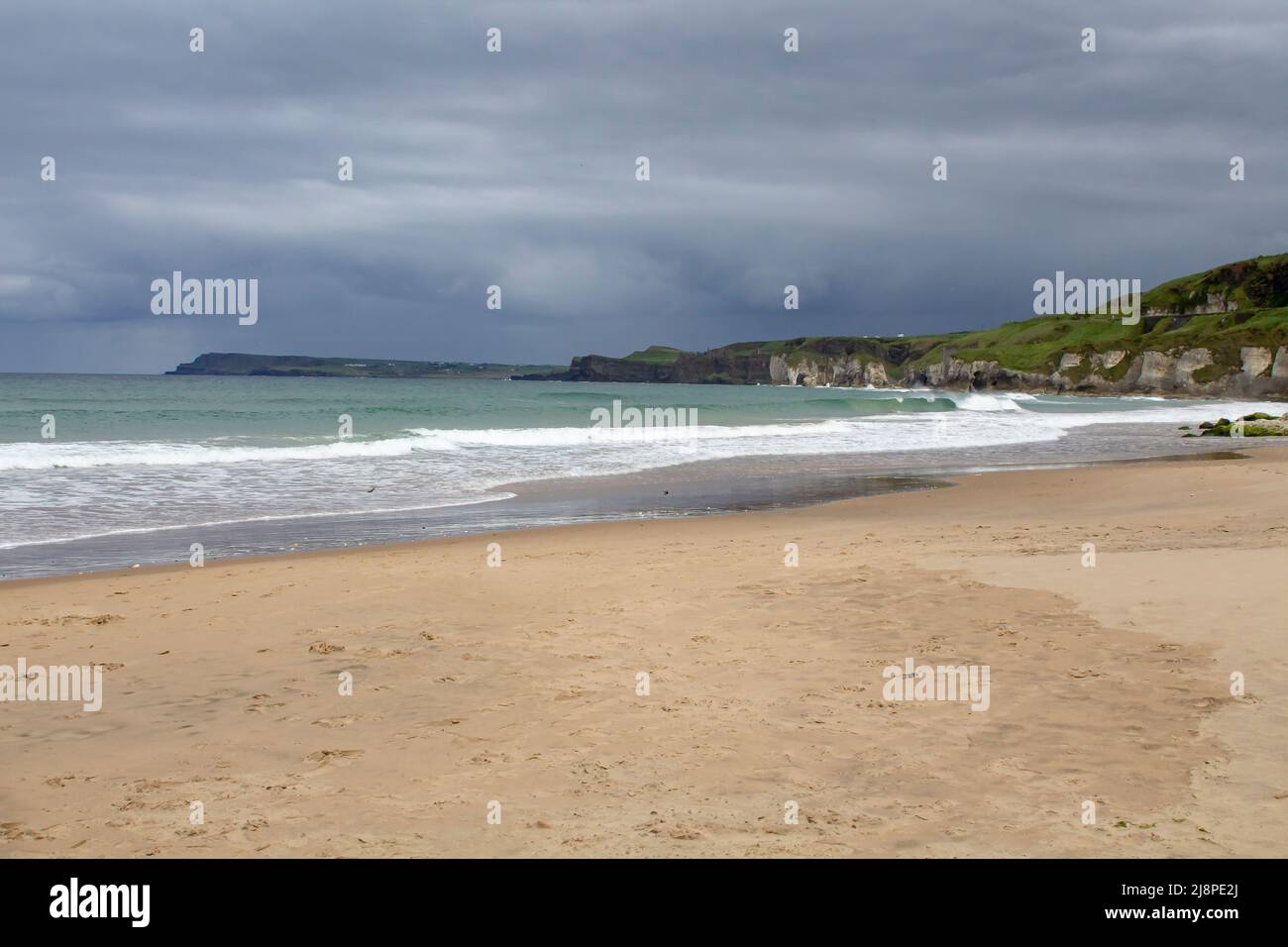 12 May 2022 The beach and shoreline at Port Ballintrae looking southward on the picturesque North East Causeway Coast of Northern Ireland in County An Stock Photo