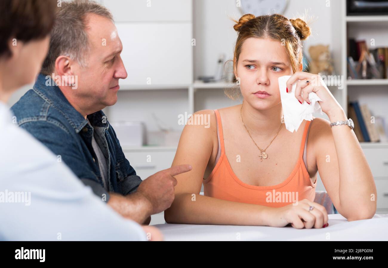 Mom and dad are supporting a sad daughter at the table Stock Photo - Alamy