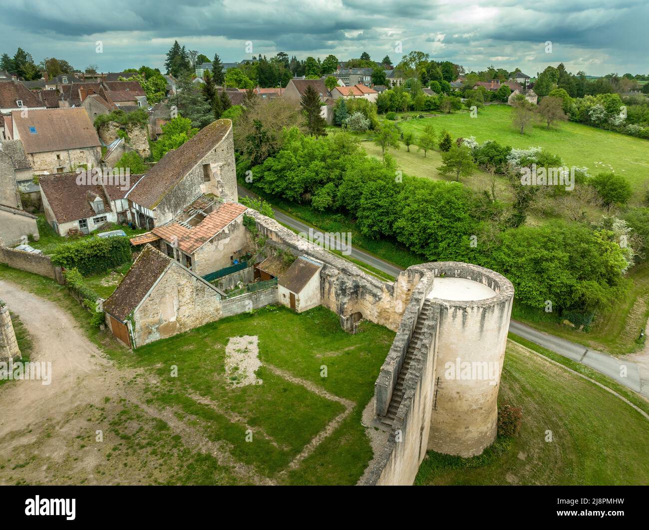 Aerial view of Ainay le Chateau from the east, small medieval town in Allier department in France with ramparts and  city gate clock tower cloudy sky Stock Photo