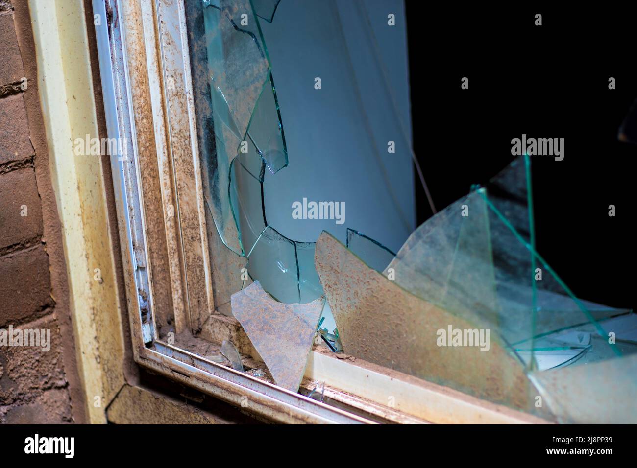 Broken bathroom window broken glass. Crime scene investigation burglar smashing glass window. Stock Photo
