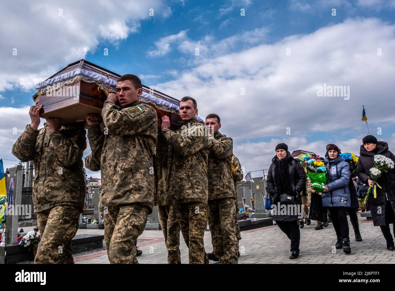 Soldiers carry a coffin of a dead soldier at Lviv cemetery. Lviv military funeral. Russia invaded Ukraine on 24 February 2022, triggering the largest military attack in Europe since World War II. Stock Photo