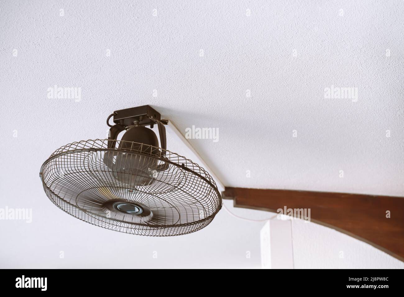 Fan with blades in a protective casing on the ceiling Stock Photo