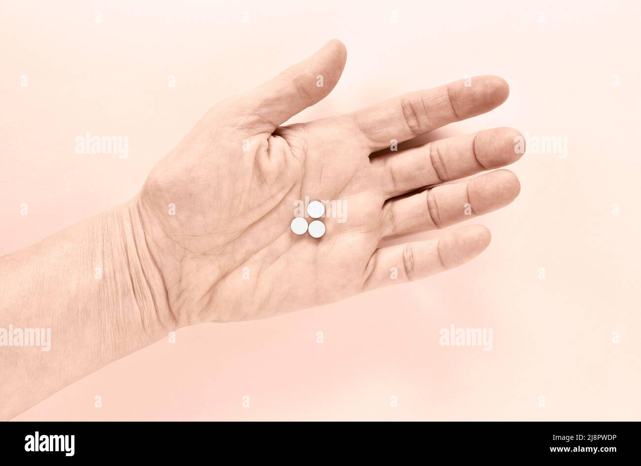 Woman hand with white  pills against colored  background Stock Photo