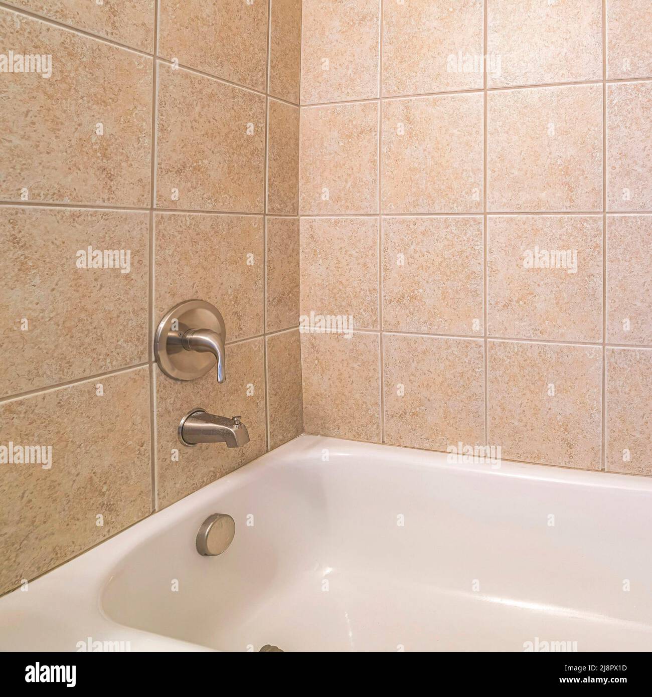 Square Alcove bathtub close up with brown ceramic tiles surround Stock ...