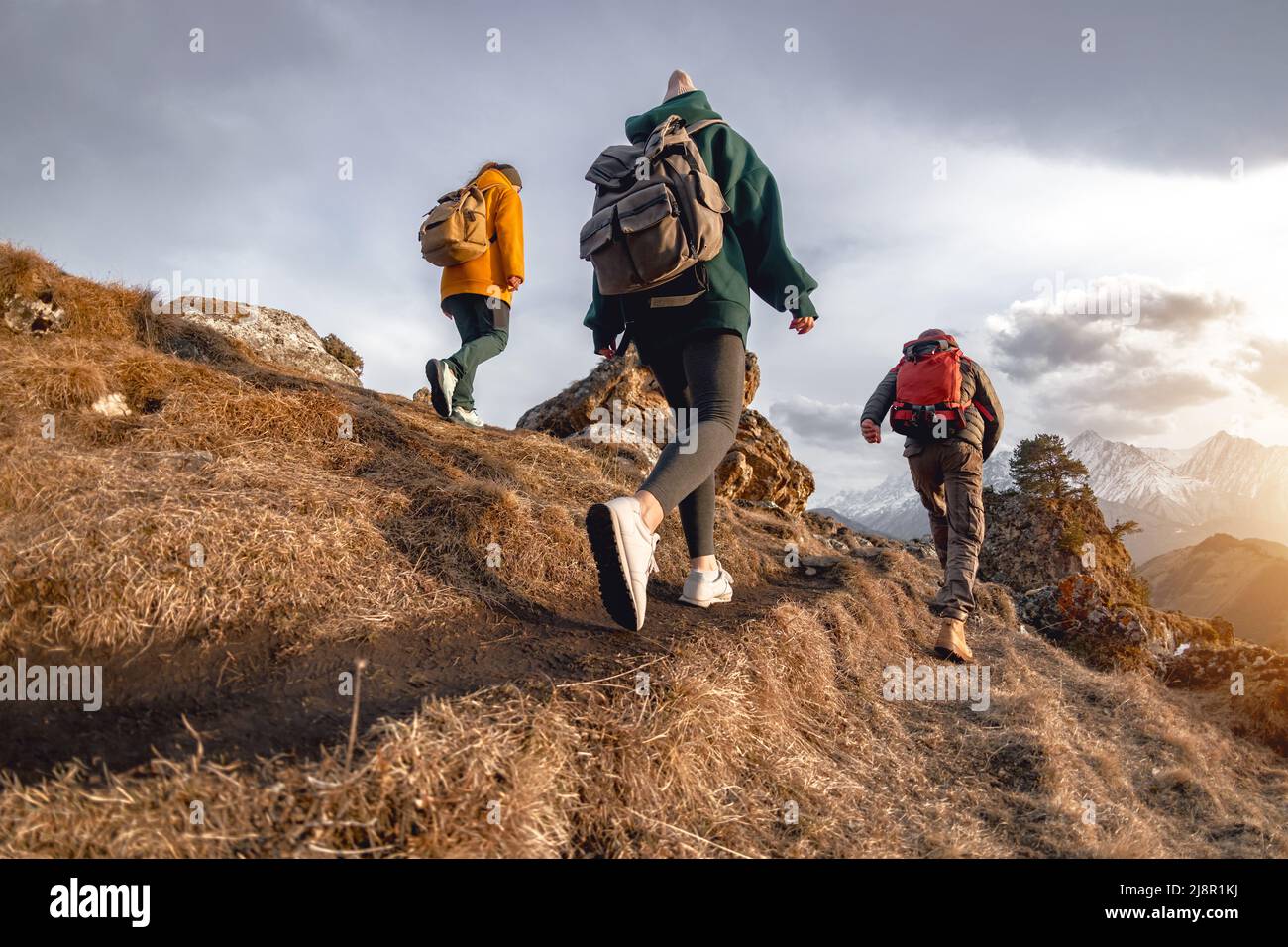 Young hikers with small backpacks walks in mountains Stock Photo