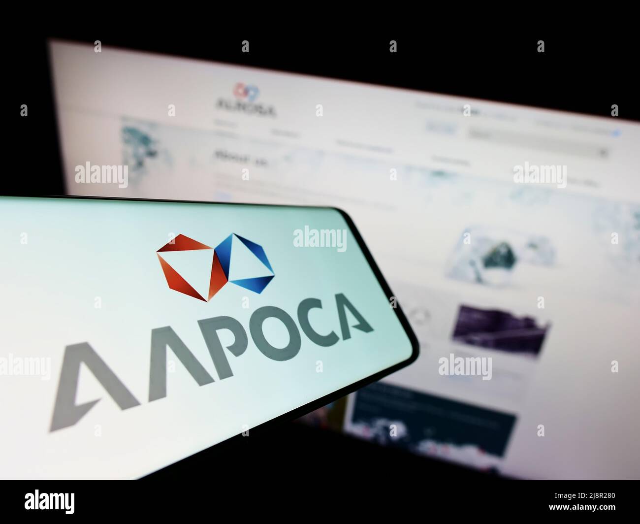 Cellphone with logo of Russian diamond mining company Alrosa PJSC on screen in front of business website. Focus on center-right of phone display. Stock Photo