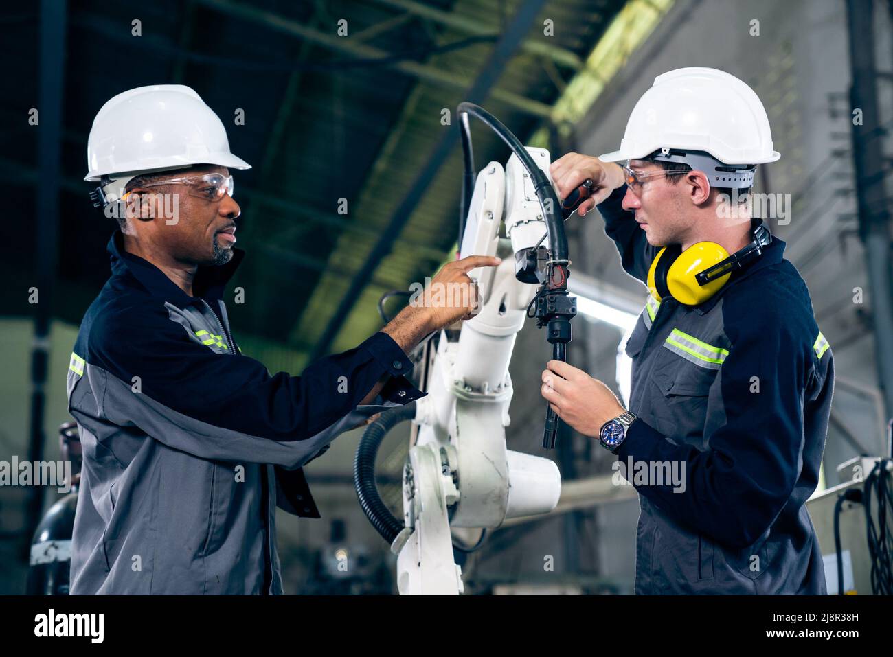Factory workers working with adept robotic arm in a . Industry