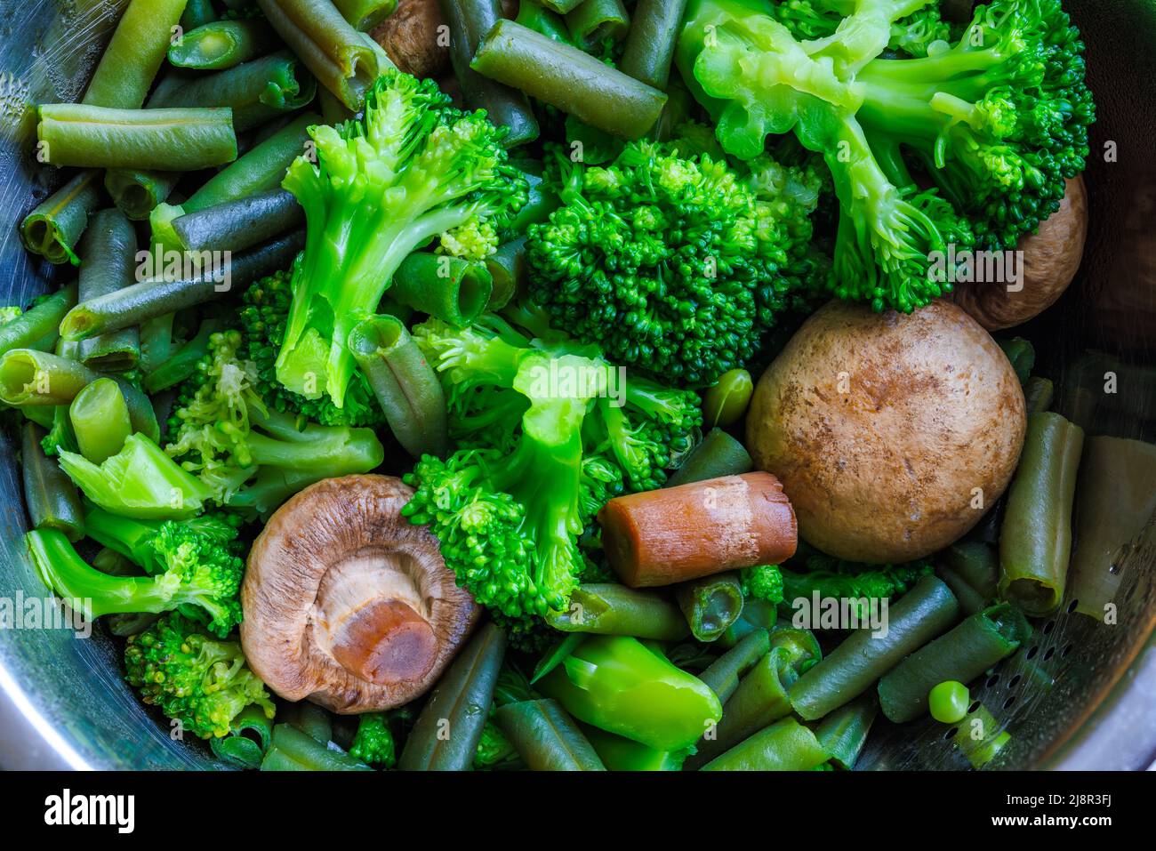 boiled green vegetables in stainless steel colander fullframe