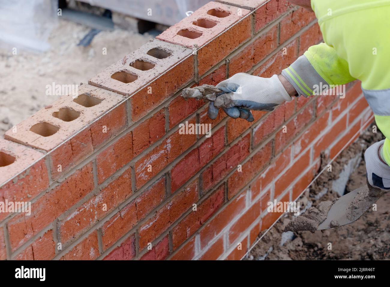 Bricklayer filling joints in the brick wall. Pointing joints in the