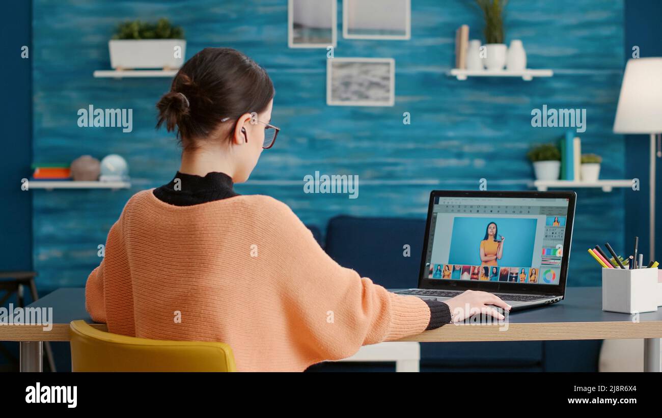 Graphic designer retouching picture for online editing class on laptop, using software to grade
