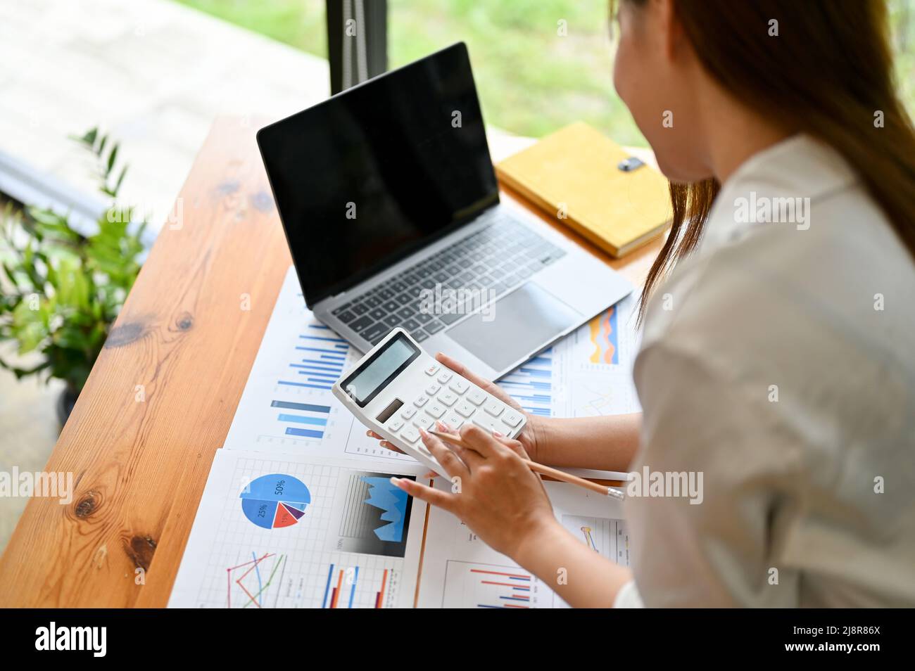 Female accountant using calculator, reviewing financial accounts on the ...