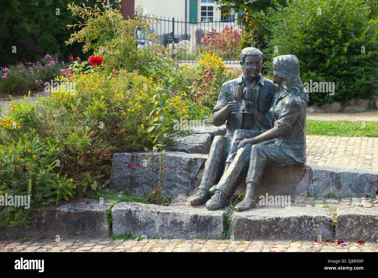 Schliengen, Lörrach, Baden-Württemberg, Germany - September 10, 2021: A sculpture in the castle park shows a couple sitting down on the stone steps an Stock Photo