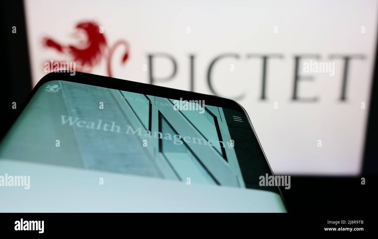 Smartphone with website of Swiss banking company Banque Pictet Cie SA on screen in front of business logo. Focus on top-left of phone display. Stock Photo