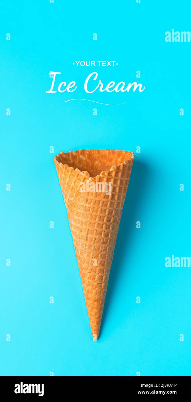 Crispy waffle cone on a blue background close-up. Top view, vertical. Stock Photo