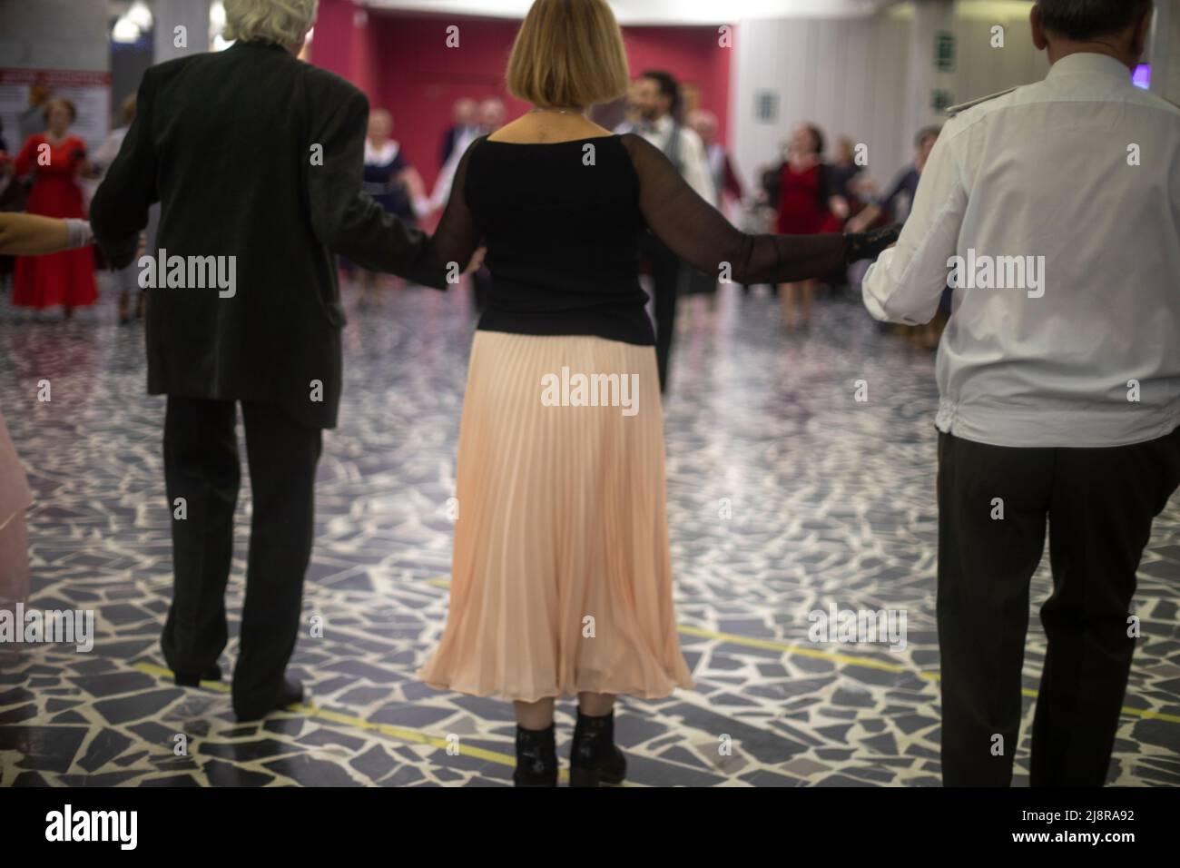 Homecoming. Adults dance. Pensioners at ball. Old people are resting. Men and women dance in hall. Stock Photo