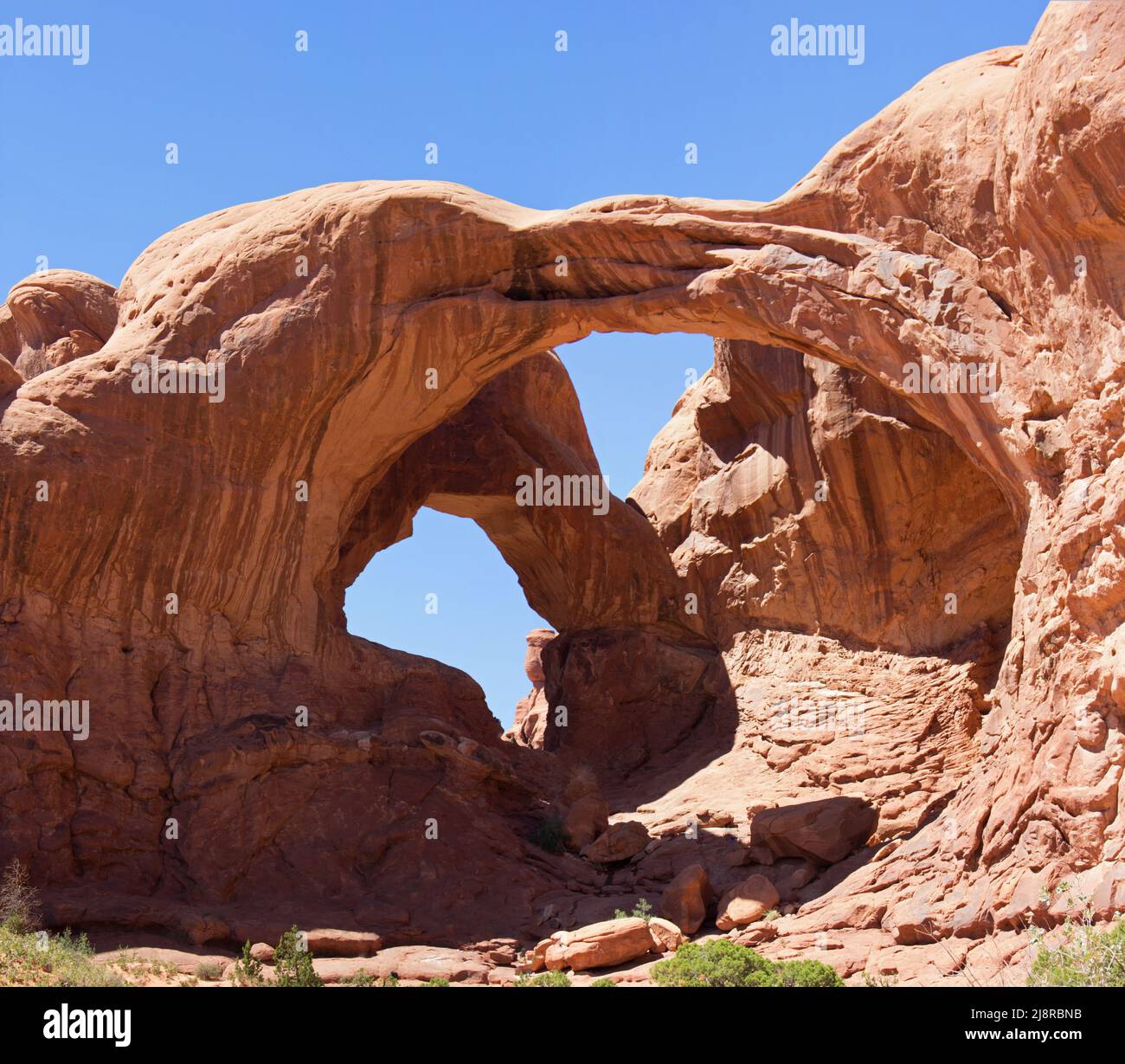 Double Arch in Arches National Park Utah America. Remarkable Landmark. Natural stone Arch in front of Blue Sky. High Resolution in Poster format. Stock Photo