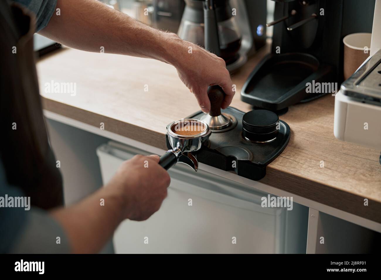 Close-up of hand Barista cafe making coffee with manual presses ground  coffee using a tamper at the coffee shop 27393656 Stock Photo at Vecteezy