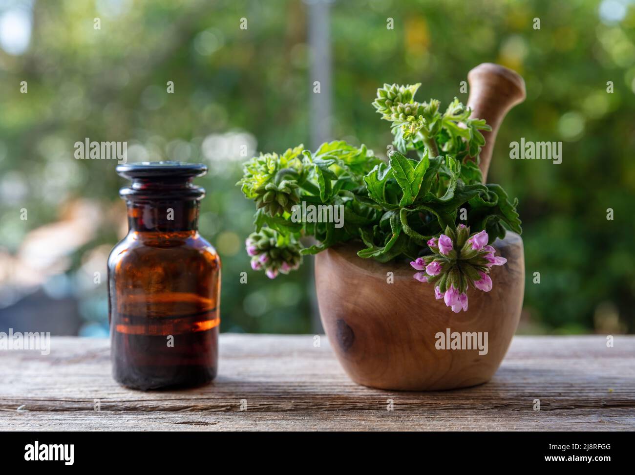 Citronella geranium essential oil glass bottle on wooden table, close