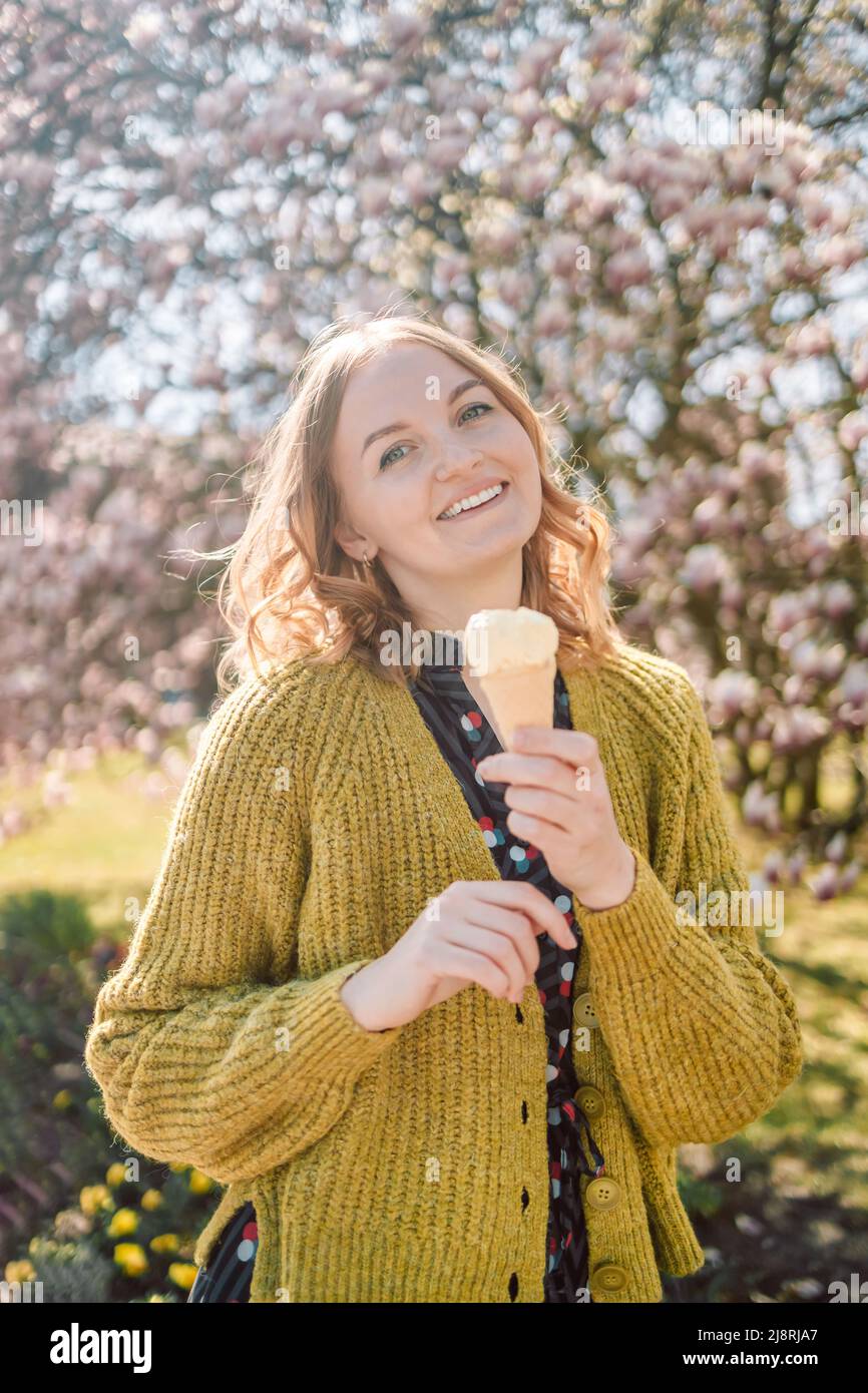 Beautiful young blonde hair woman eat ice cream outdoors in hot summer