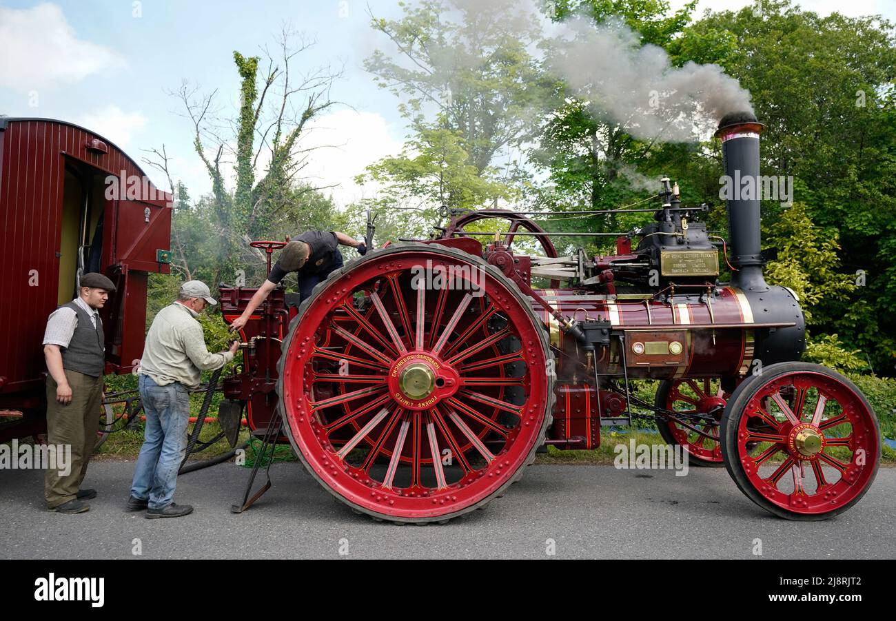 People work on the Foden General Purpose Engine 3384, 'Wattie Pollock' as it stops to take on water in Kimbridge, Hampshire, whilst it travels to the Mid Hants Railway, also known as the Watercress Line, to take part in their Vintage Vehicles weekend which runs from 20-22 May. Stock Photo