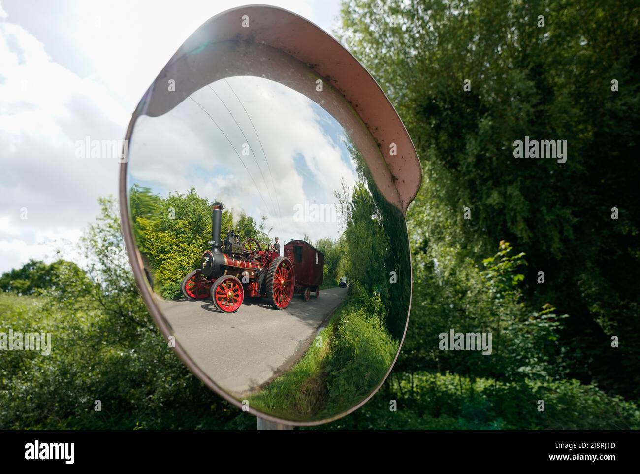 The Foden General Purpose Engine 3384, 'Wattie Pollock' is reflected in a mirror as it is driven along the Kimbridge Lane in Kimbridge, Hampshire, as it travels to the Mid Hants Railway, also known as the Watercress Line, to take part in their Vintage Vehicles weekend which runs from 20-22 May. Stock Photo