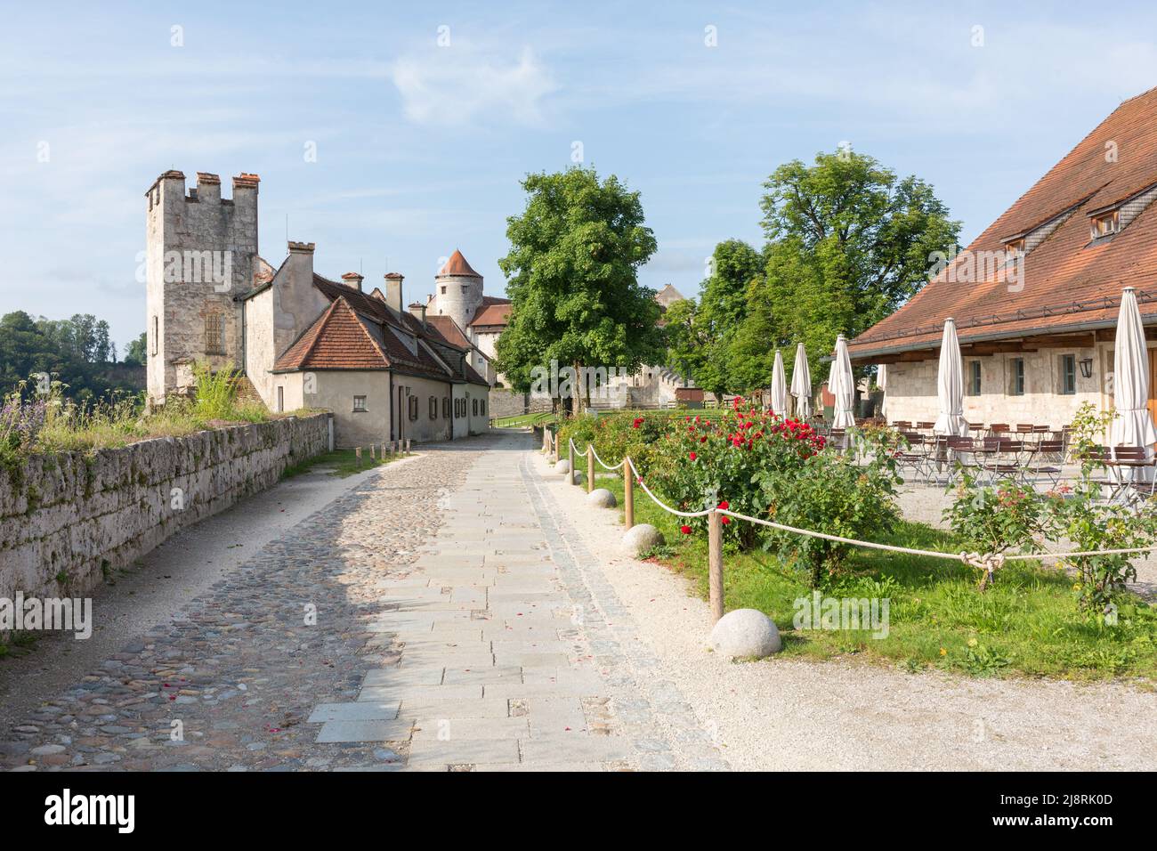 Burghausen, Germany - Jul 25, 2021: View along a path inside the walls of Burghausen castle. On the right the castle cafe. Stock Photo