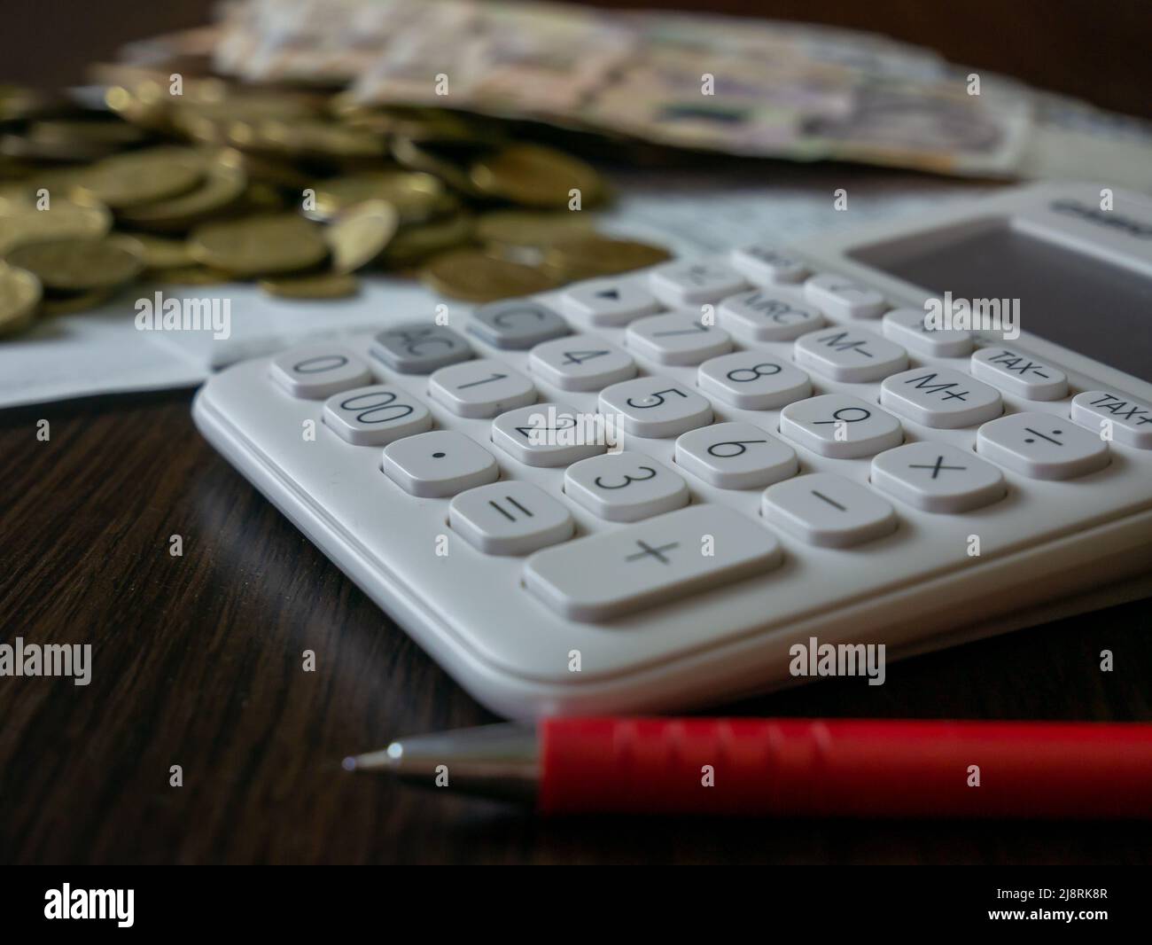 The white calculator and ukrainian money isolated on dark background Stock Photo