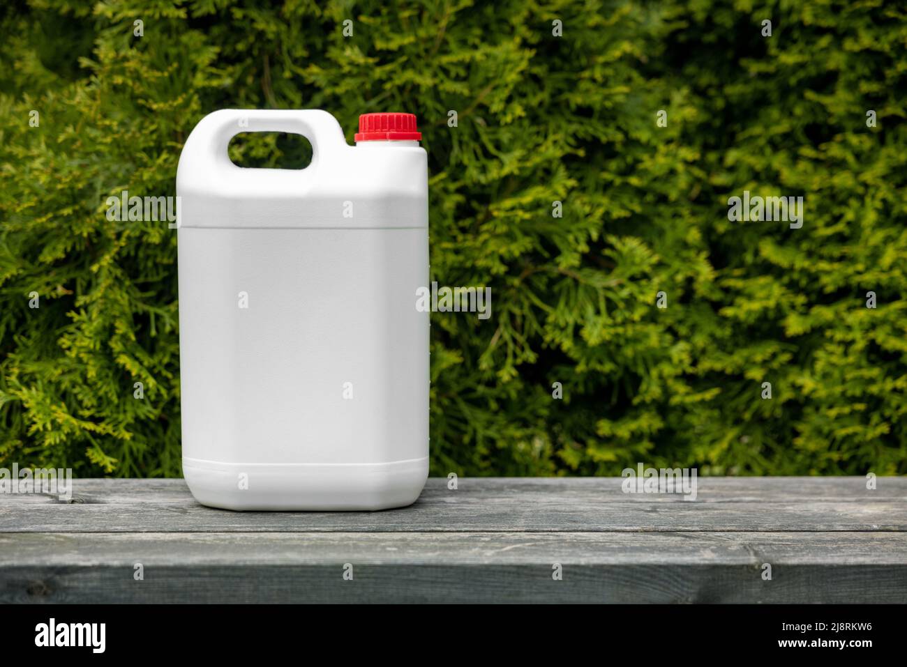 white blank plastic fertilizer jerry can for conifer garden plants. copy space Stock Photo
