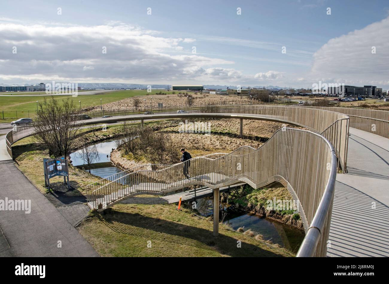 Reykjavik, Iceland, April 25, 2022: stylefully designed pedestrian overpass with Vatnsmyri domestic airport in the background Stock Photo