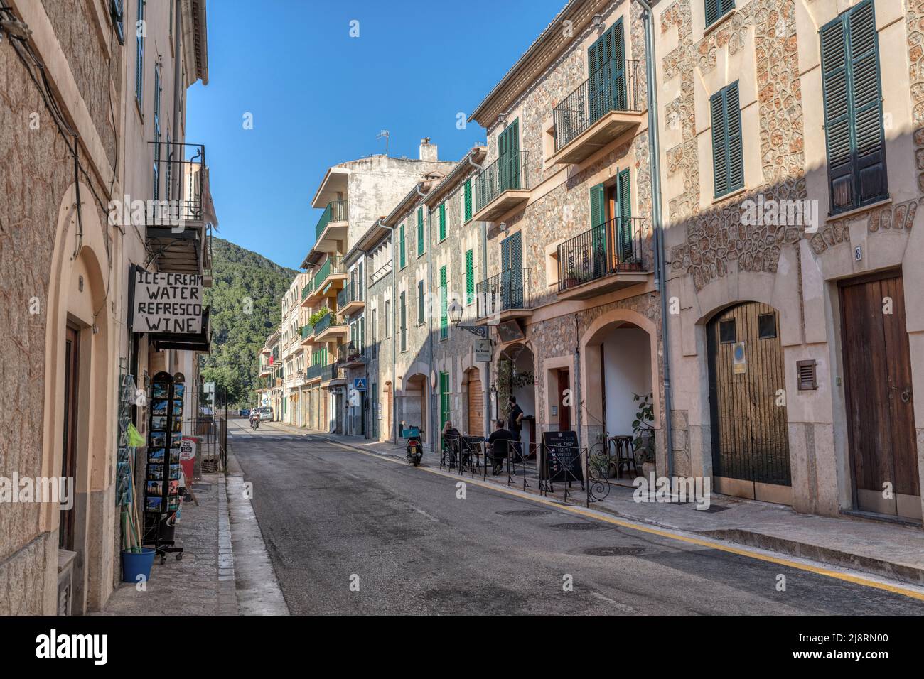 Carrer Comte de Sallent, main street in Banyalbufar with shops, restaurants and cafes in UNESCO world heritage Serra De Tramuntana mountains Stock Photo