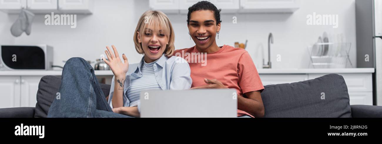 cheerful african american man near happy girlfriend waving hand during ...