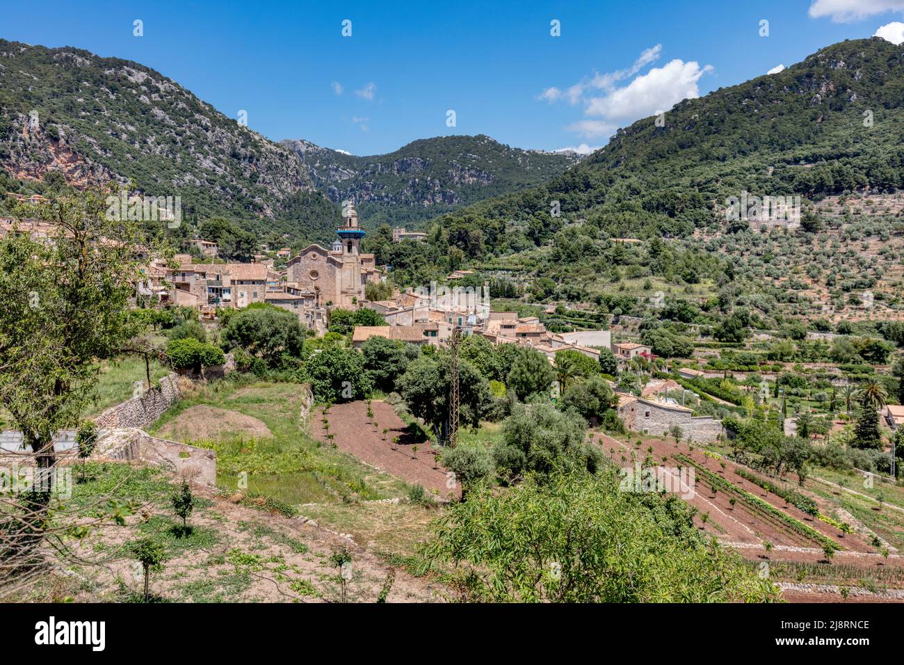 East Valldemossa with Church de Sant Bartomeu in centre and terraced farming nestled in the UNESCO world heritage site Serra de Trumantana mountains Stock Photo