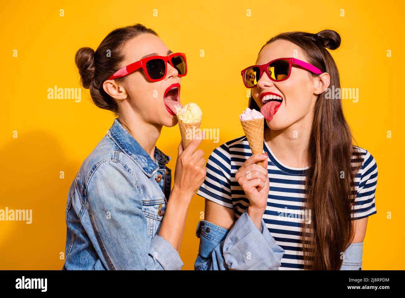 Photo of two ladies have free time eat tasty fresh ice cream wear denim