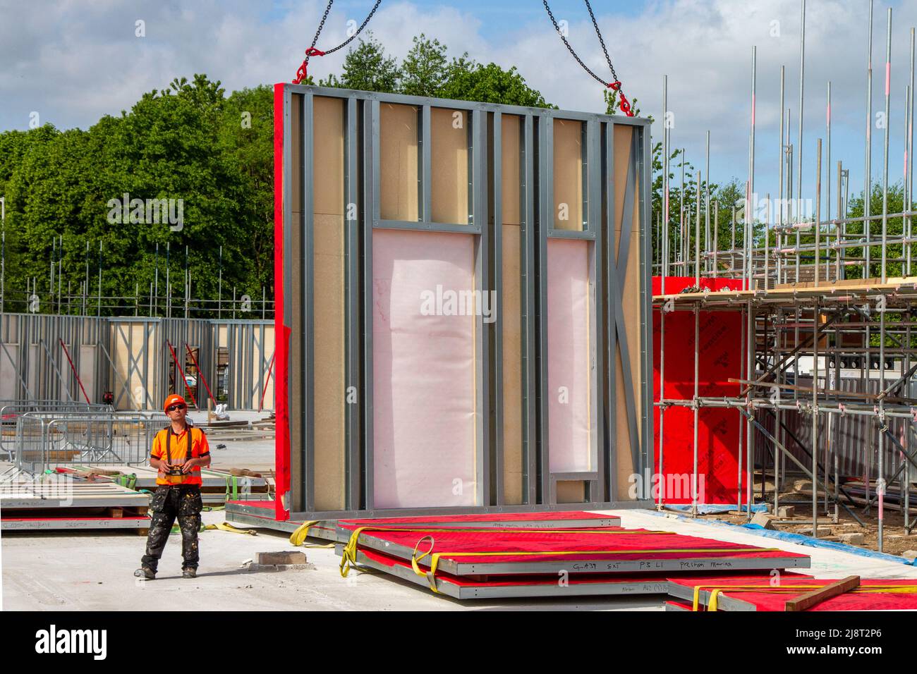 Morar UK's care homes Preston, Lancashire: May 2022.  Bright sunshine and light winds, essential weather conditions for the installation of red Wraptite a unique external airtight solution, which is vapour permeable, yet airtight; membrane & insulation on construction site. Simply UK New Build Care Home in Riverside Dockland. Credit: MediaWorldImages/AlamyLiveNews Stock Photo