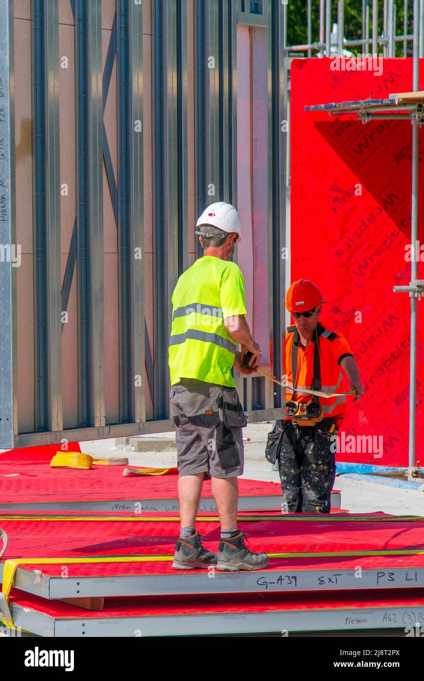 Morar UK's care homes Preston, Lancashire: May 2022.  Bright sunshine and light winds, essential weather conditions for the installation of red Wraptite a unique external airtight solution, which is vapour permeable, yet airtight; membrane & insulation on construction site. Simply UK New Build Care Home in Riverside Dockland. Credit: MediaWorldImages/AlamyLiveNews Stock Photo