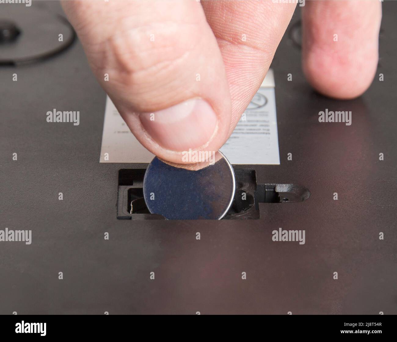 Installing a new round coin cell battery in an electrical appliance