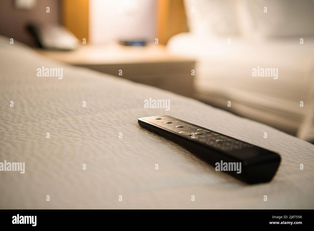 Hotel Television Remote on a Bed. Satellite Channels Watching During