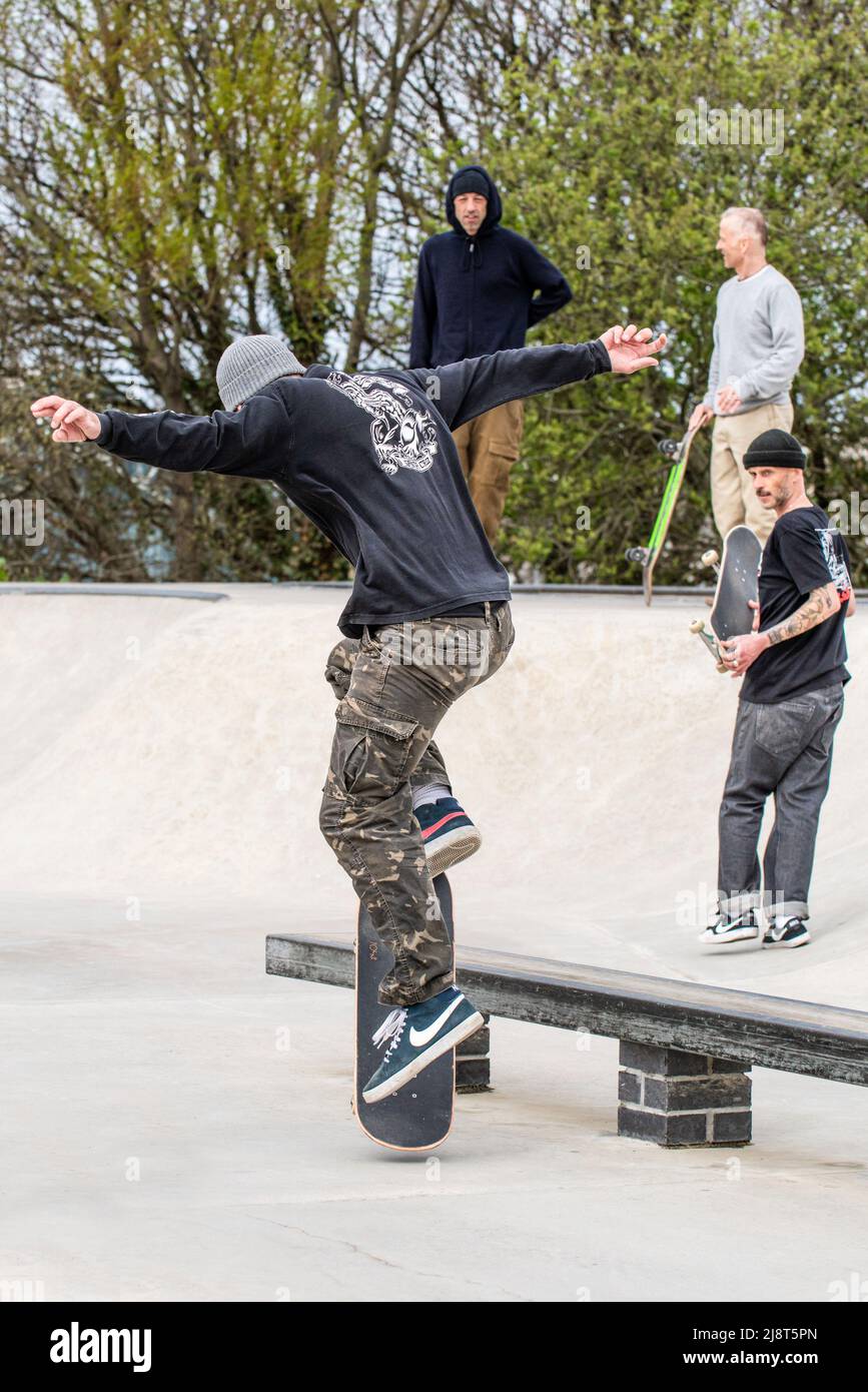 A mature male skateboarder performing a boardslide railslide trick at Newquay Concrete Waves