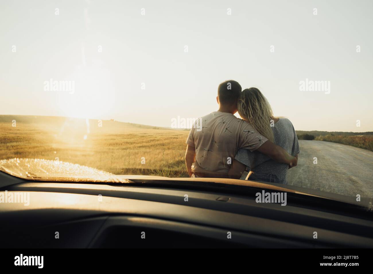 Couple Hugging On Car Bonnet Looking Away Los Angeles California