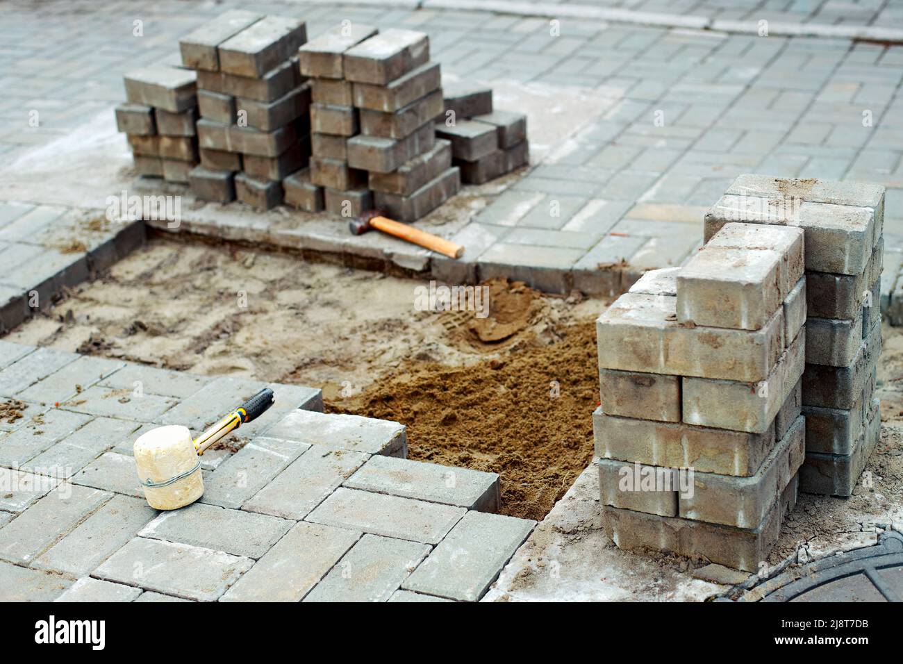 View of new paving slabs and concrete blocks on summer day at construction site. Stone blocks stand in stack. Repair of square and sidewalks. Restoration of road surface. Stock Photo